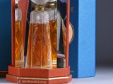 a bottle of perfume in a blue box next to a blue box with a clock on it