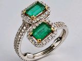 un gros plan d'une bague sertie de deux émeraudes