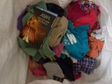 a bag full of clothes and a book on the bed