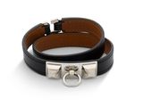 un gros plan sur un bracelet en cuir noir muni d'un fermoir en argent