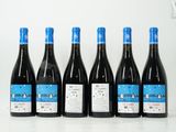 six bouteilles de vin sont alignées sur une table