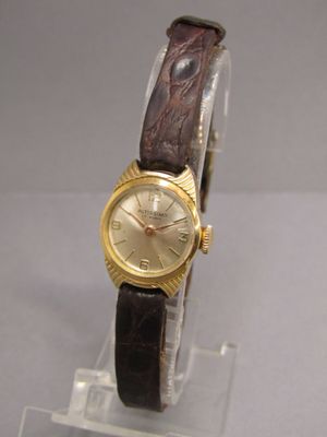 une photo d'une montre-bracelet avec un cadran doré et un bracelet en cuir marron