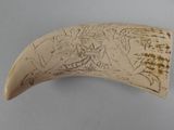 a piece of ivory that has been carved with writing on it