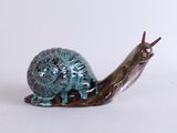 un petit escargot posé sur une surface blanche