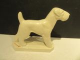 a small white dog statue on a white table