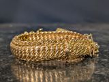 a gold bracelet on a table with a black background