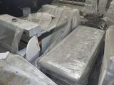 many mattresses that are wrapped in plastic in a room