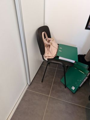 a chair and a table in a room with a bag on it