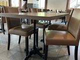 tables and chairs in a restaurant with a large window in the background
