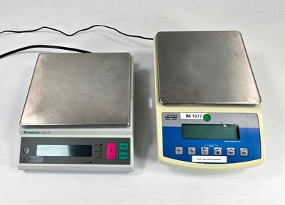 deux balances électroniques posées sur un plateau de table blanc