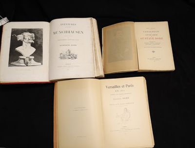trois livres ouverts posés sur une table, sur fond noir