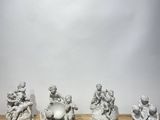 five figurines on a wooden table with a white background