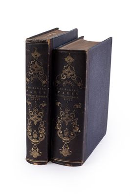 two old books sitting on top of each other on a white surface