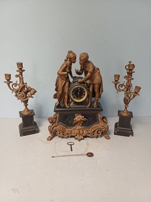 a clock that is sitting on a table next to some candles