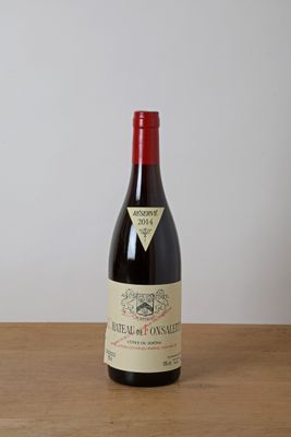 une bouteille de vin rouge posée sur une table en bois