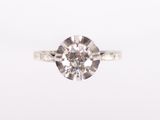 a close up of a diamond ring on a white surface