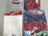 un tas de t-shirts dans des sacs en plastique posés sur une table
