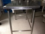 a stainless steel table in the middle of a kitchen