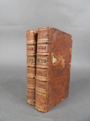 deux vieux livres posés l'un sur l'autre sur une table