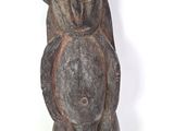 une vieille statue en bois représentant un gorille tenant un morceau de bois
