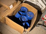 three blue barrels in a cardboard box next to a shopping cart