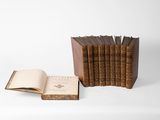 several books are stacked on top of each other on a white surface