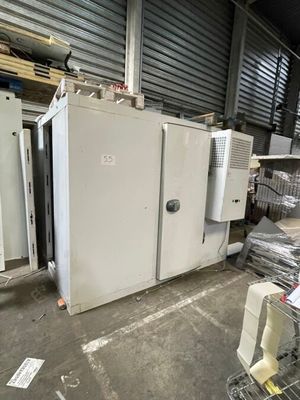 un réfrigérateur blanc posé dans un entrepôt à côté d'autres appareils électroménagers