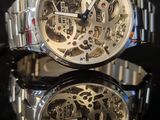 a close up of a watch on a black surface