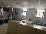 une pièce équipée d'un bureau, de chaises et d'un écran