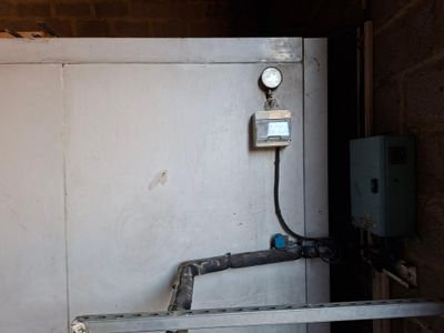 une porte métallique sur laquelle est fixé un compteur, dans un immeuble