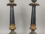 une paire de bougeoirs noirs et dorés posés sur une table
