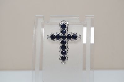 a cross made out of silver and black stones