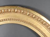 an image of a gold framed mirror on a gray wall