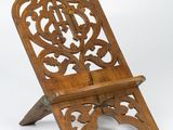 une vieille chaise en bois dont le dossier et l'assise sont sculptés, sur fond blanc