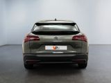 the rear end of a grey car in a white room