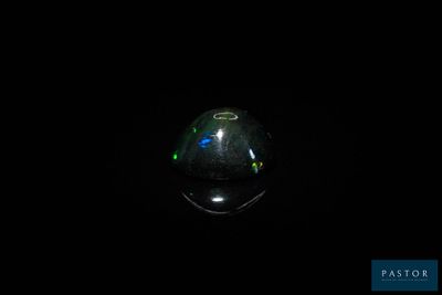 une image d'une pierre oplite noire dans l'obscurité