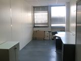 une pièce avec un bureau, des armoires et une fenêtre