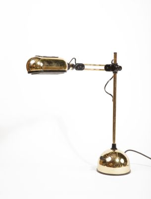 une image représentant une lampe de bureau dorée sur fond blanc