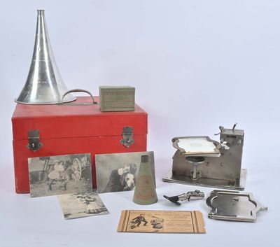 une boîte rouge ornée d'images et surmontée d'une clochette argentée