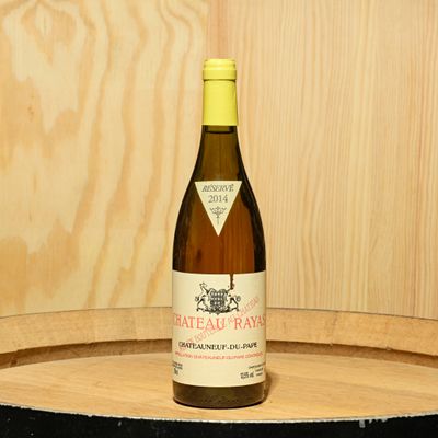 une bouteille de vin posée sur un tonneau en bois