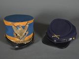 pair of military hats with eagle emblem on them on a gray surface