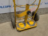 a small yellow hand truck with a sign on it
