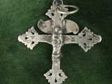 silver cross on a green cloth with a key in the middle