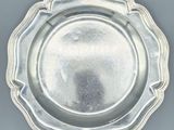 silver plate with scalloped edge on grey background