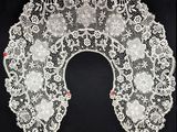 un gros plan sur un col en dentelle blanche sur fond noir