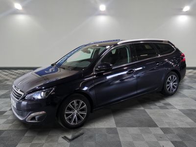Une voiture noire est garée dans une grande pièce au sol carrelé.