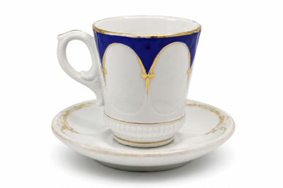 tasse à café bleue et blanche avec sa soucoupe, posée sur une soucoupe