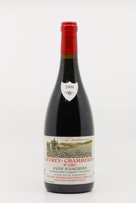 a bottle of red wine sitting on top of a white table
