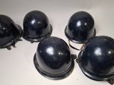 four black helmets are lined up on a white surface
