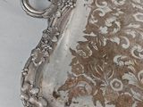 a silver tray that has a floral design on it